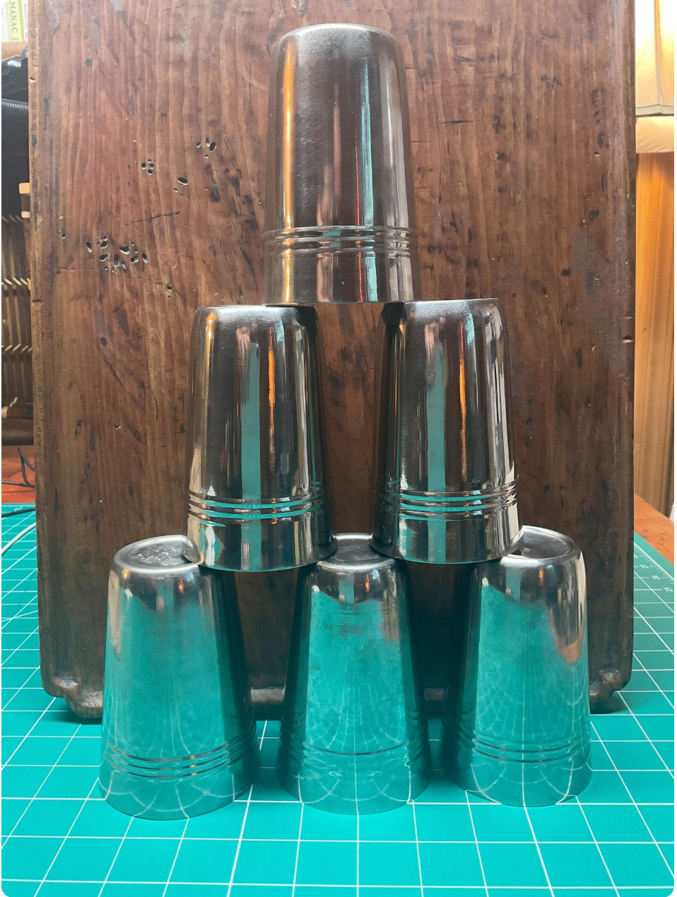 Set of metallic shot glasses on a turquoise grid background