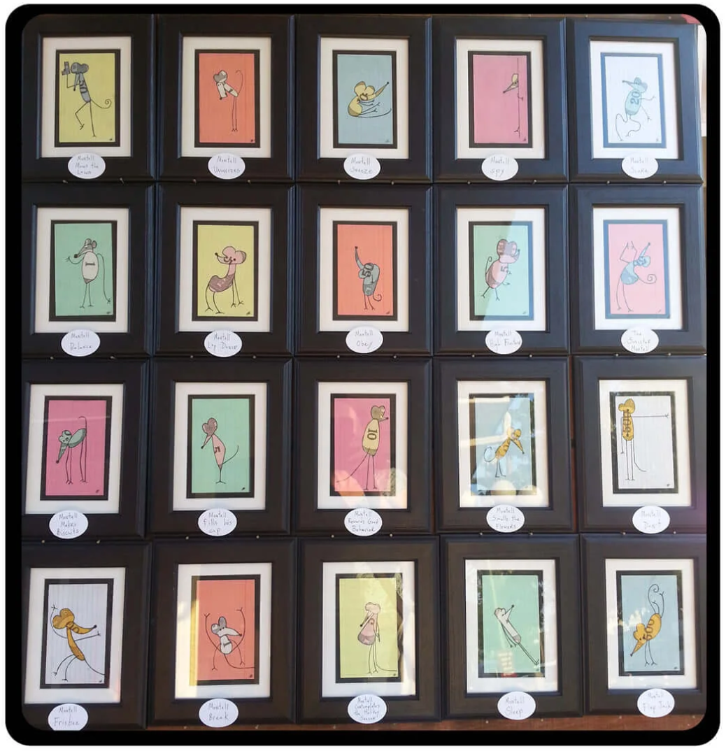 Collection of small framed artworks with colorful figures on a display board.