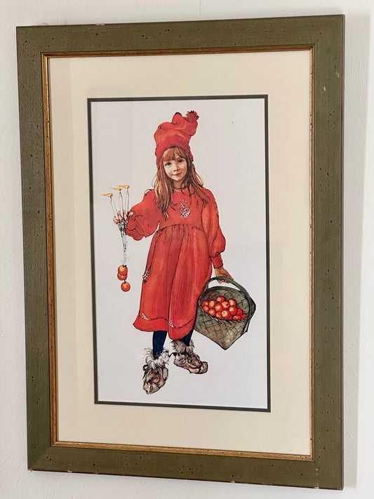 Framed illustration of a girl in a red outfit holding apples.