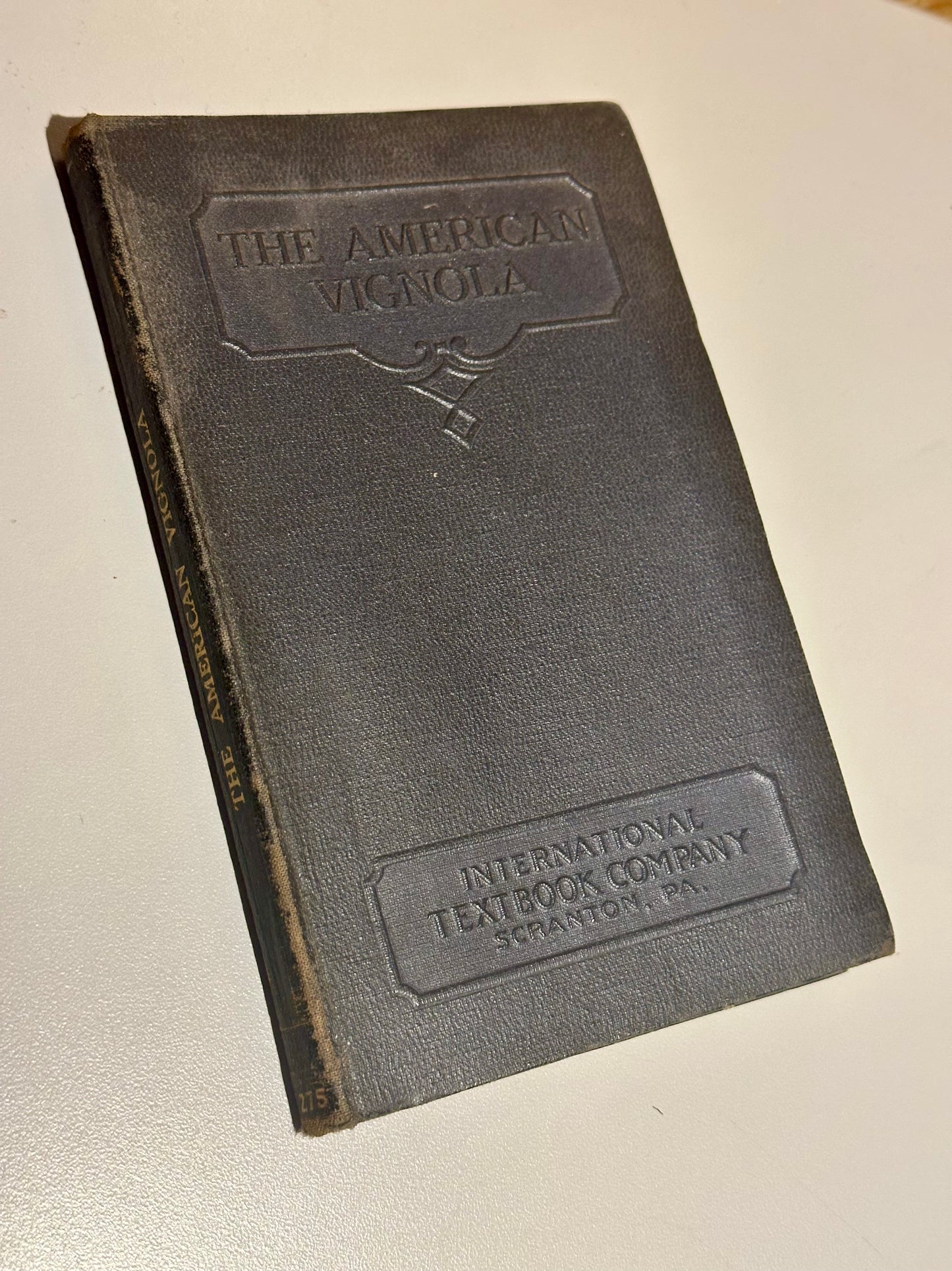 Vintage book with 'The American Vignola' and 'International Textbook Company' embossed on the cover.