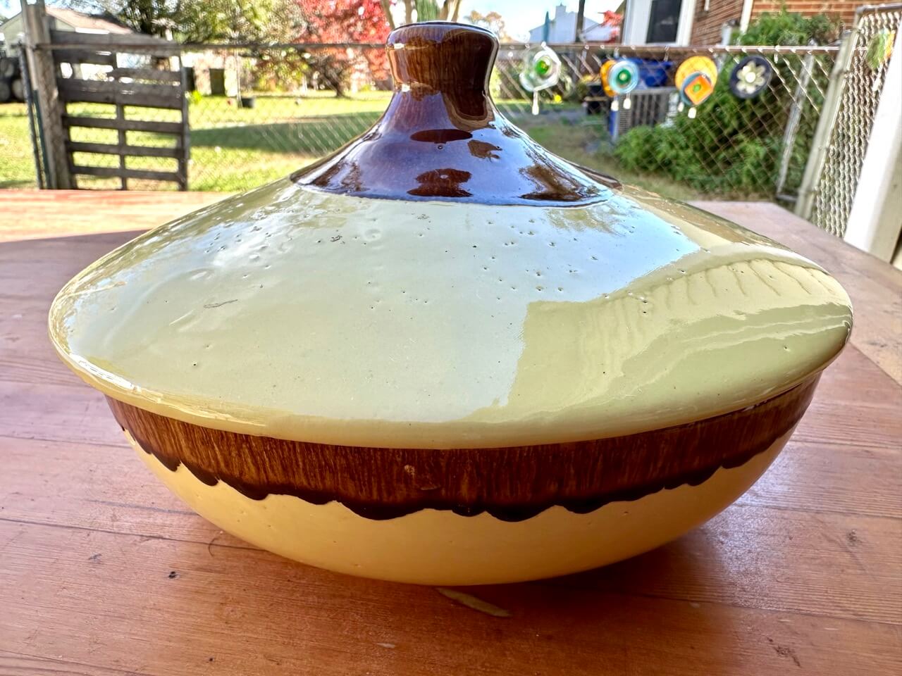 Ceramic pot with a lid on a wooden surface outdoors