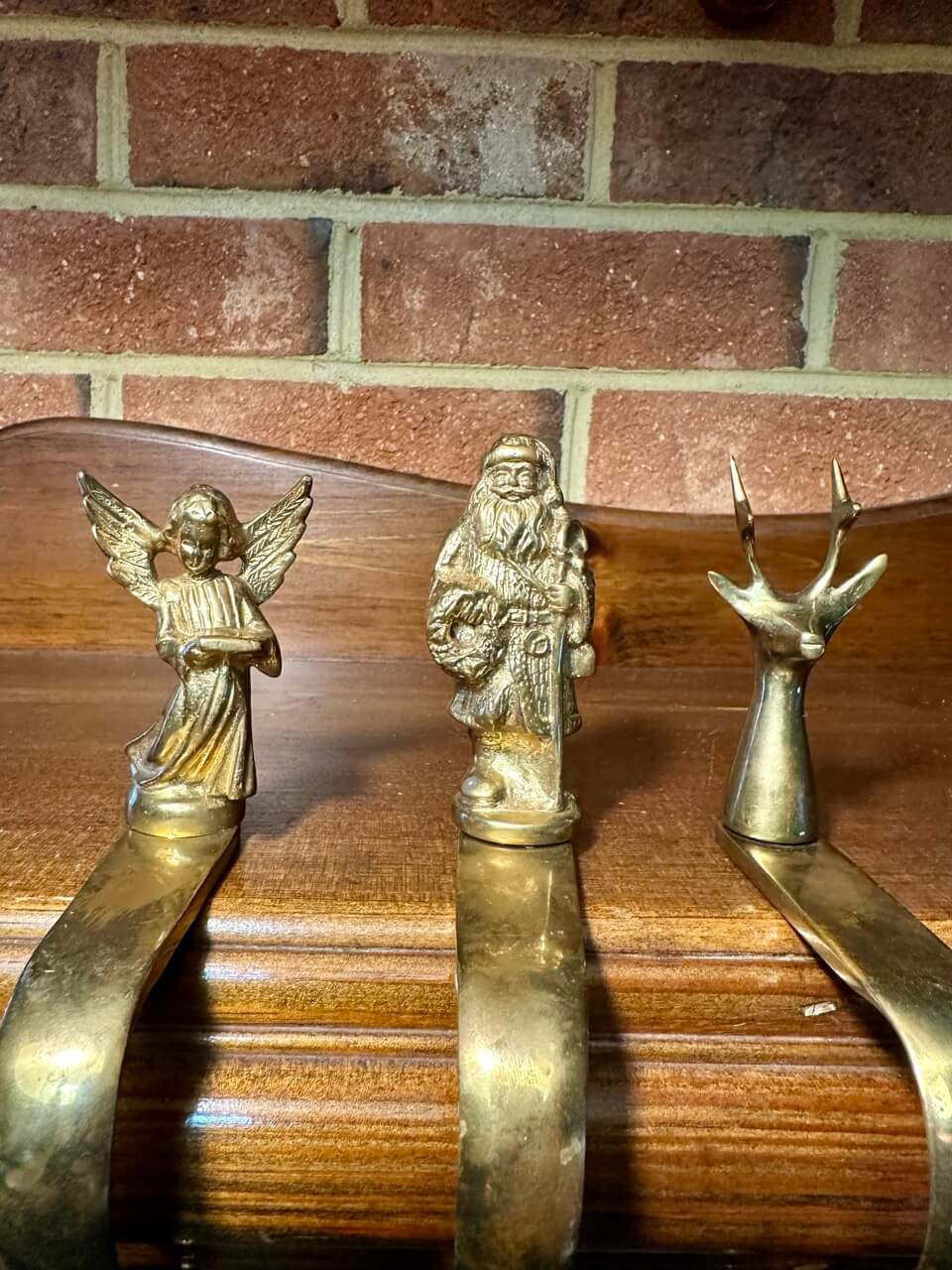 Closeup of brass figures of an angel, father christmas, and a reindeer.