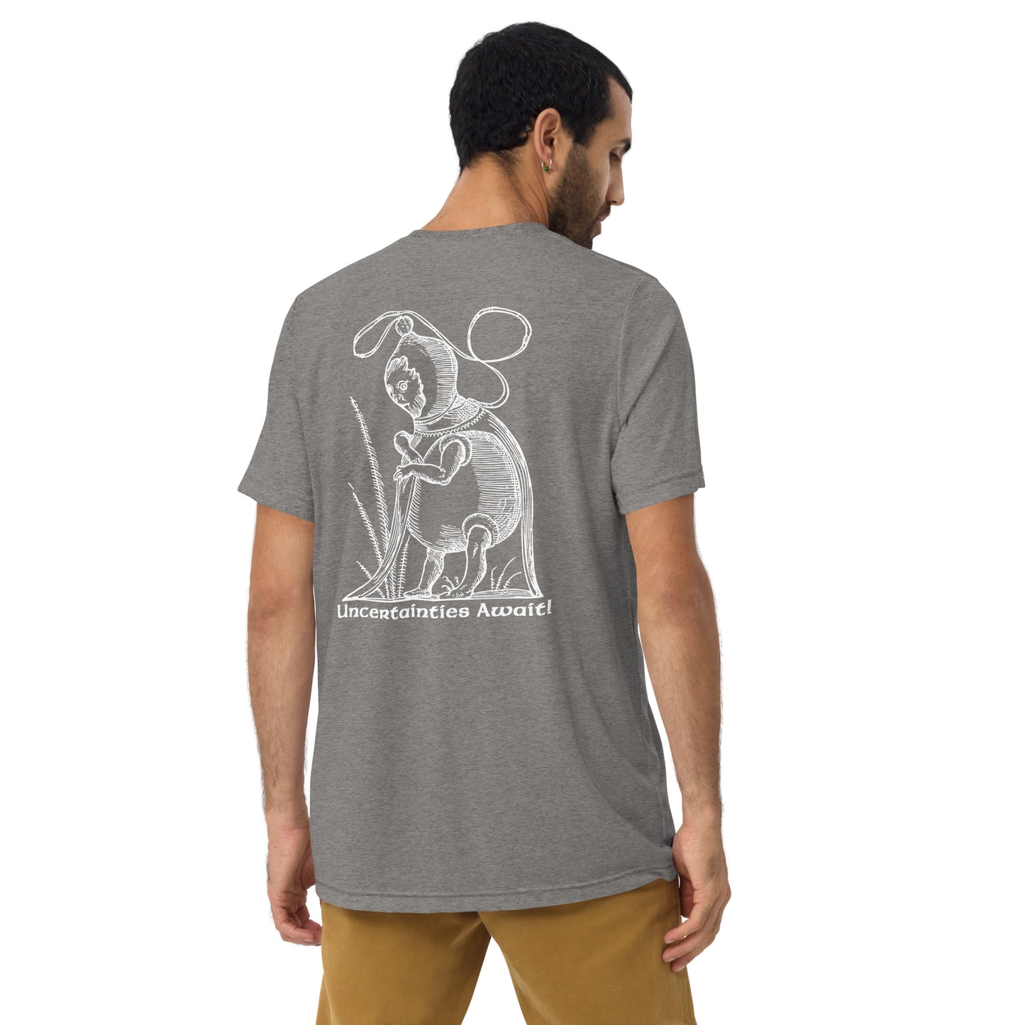Rear view of model in grey “Uncertainties Await” tee with surreal woodcut inspired by Pantagruel’s Dreams.